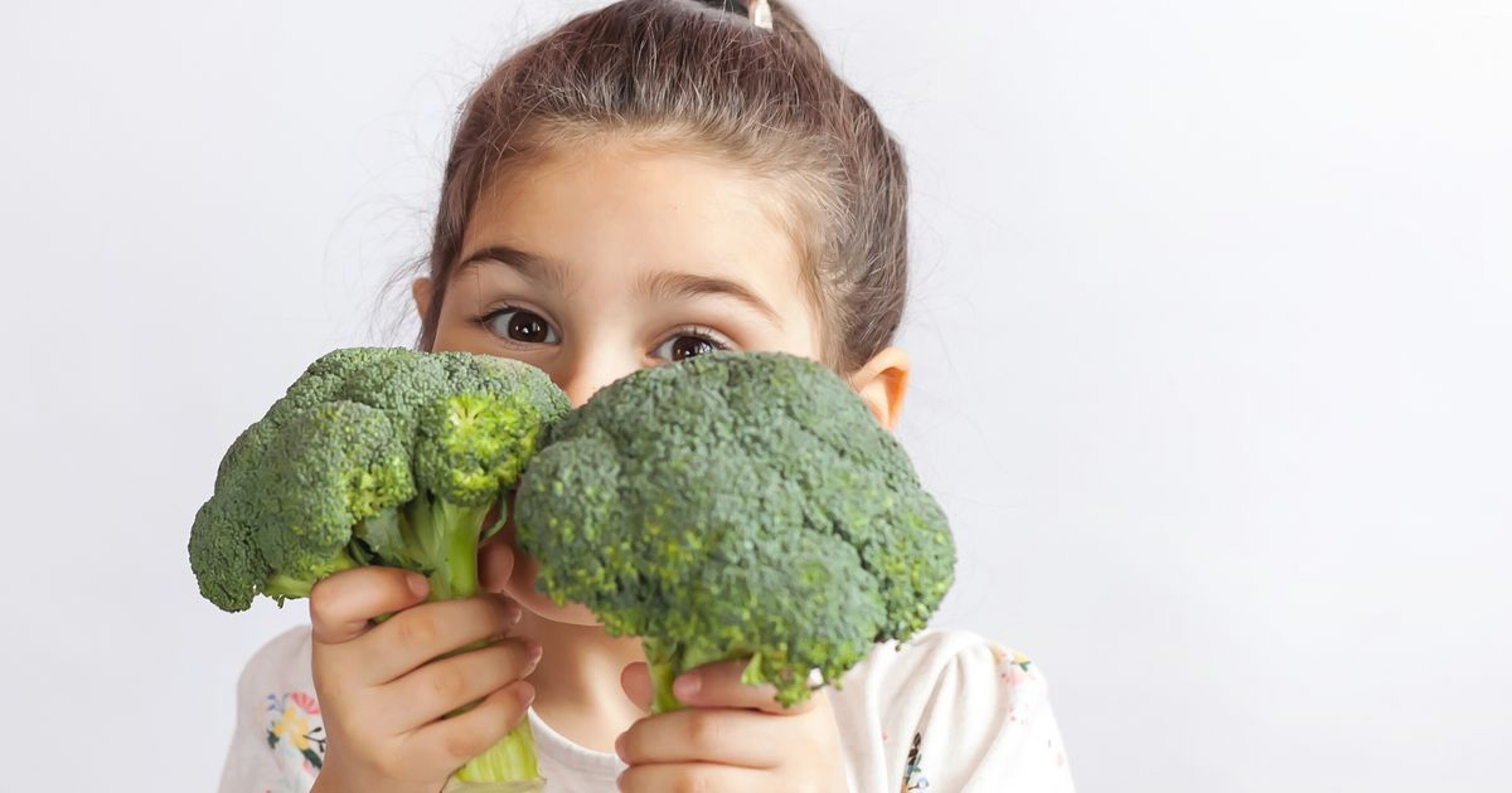 Lapsi käsissään parsakaalia.