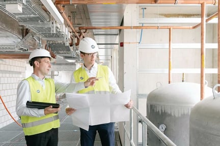 ISS:n tekniset asiantuntijat käymässä läpi piirustuksia teollisuuskohteessa.