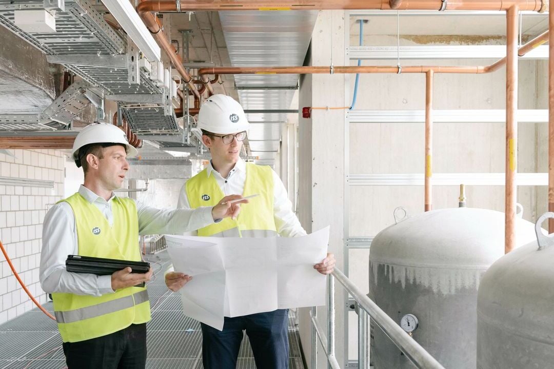 ISS:n tekniset asiantuntijat käymässä läpi piirustuksia teollisuuskohteessa.