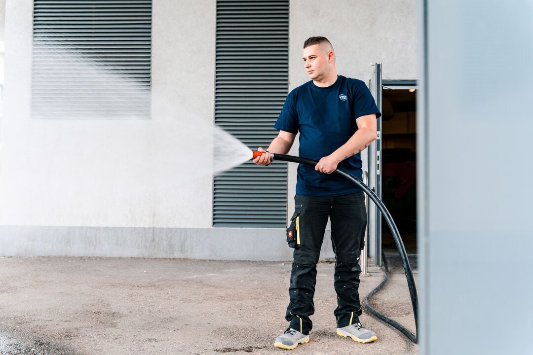 ISS:n tekninen työntekijä suihkuttaa vesiletkulla