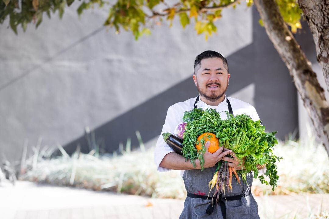 ISS:n kokki kasviksia sylissään.