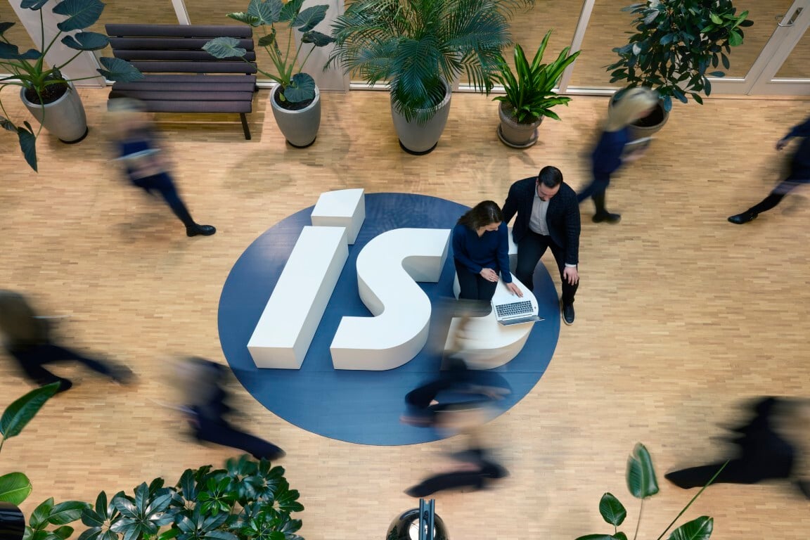 ISS logo lattialla, ja ihmisiä kävelemässä yli.